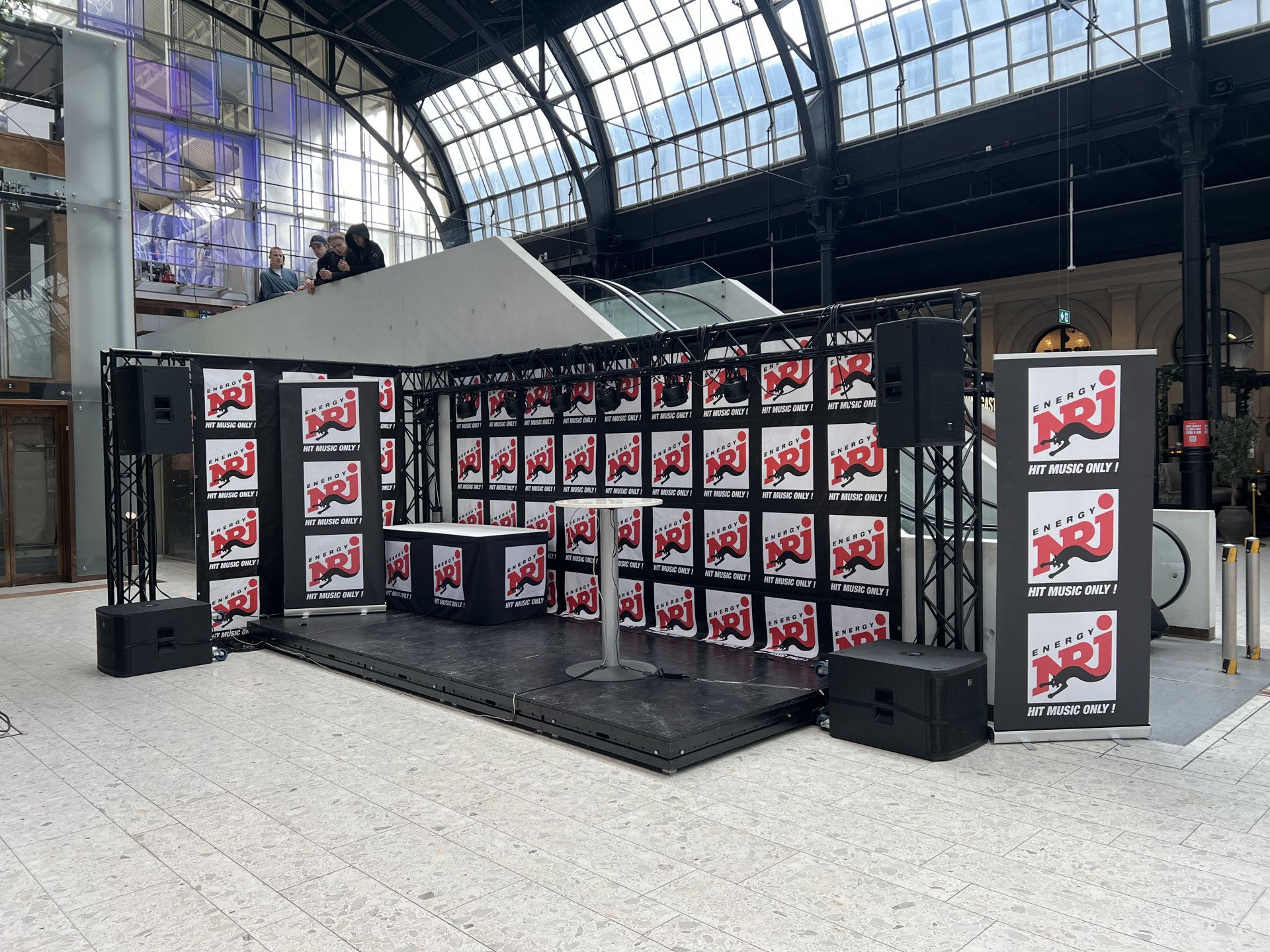 NRJ-stand med scene, høyttalere og truss i Østbanehallen